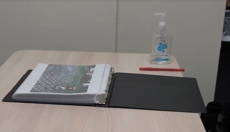 The flip-binder prototype open on a testing table beside hand sanitizer and a pen