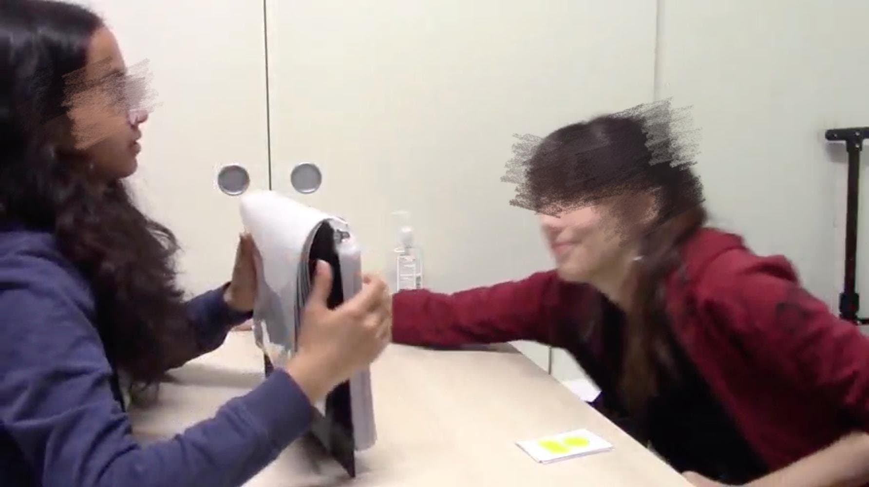 Two researchers at a table role-playing a session with the flip binder during RA training