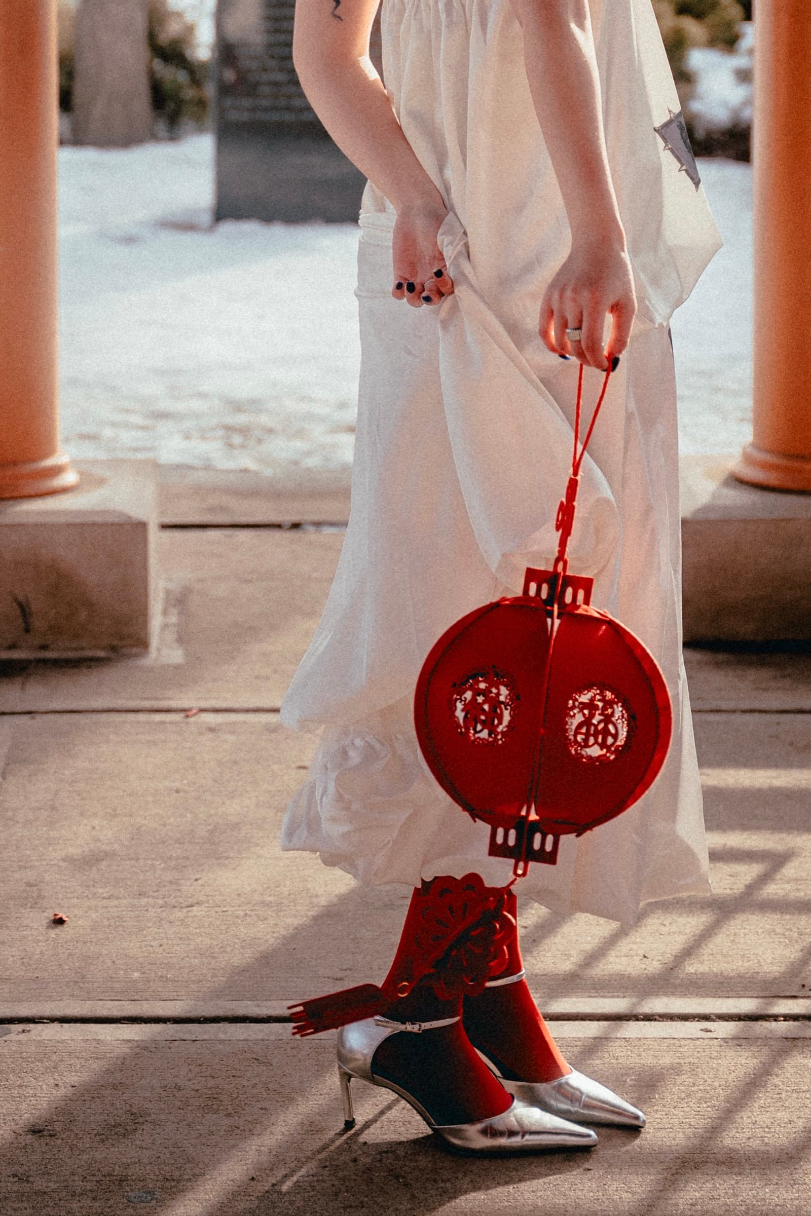 Close crop: the lantern against a white skirt, red socks and silver heels