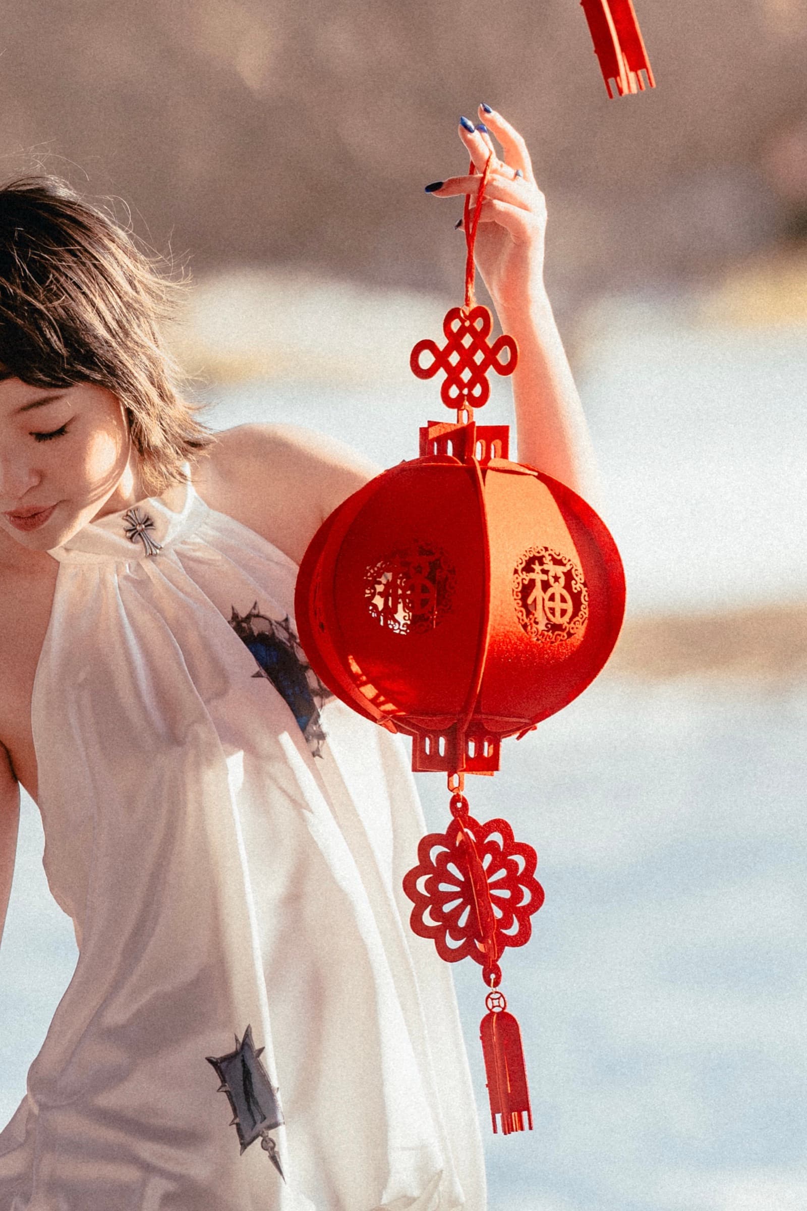 Holding the lantern up by its cord, head bowed, snow behind